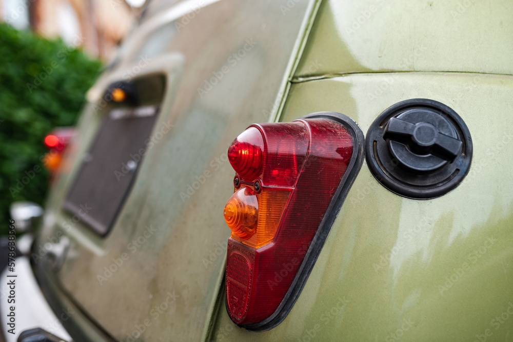 Side rear view of an old green car with taillight, turn signals, bumper