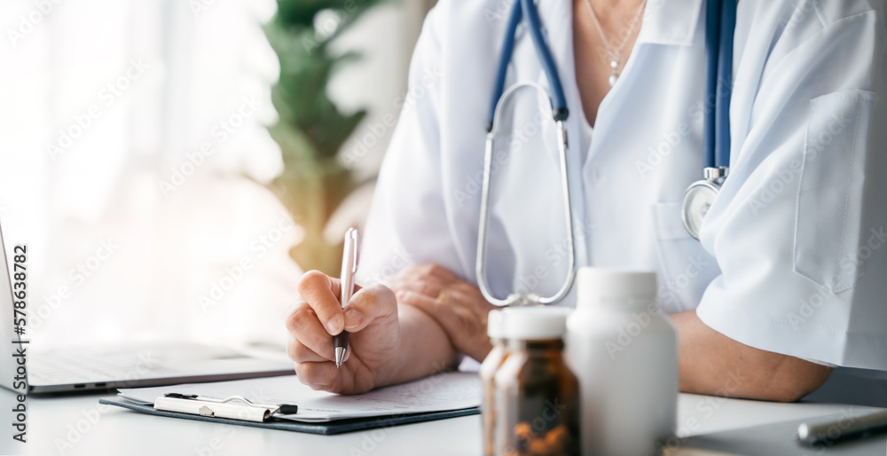 Doctor working on laptop computer and tablet and medical stethoscope on clipboard on desk, electronics medical record system EMRs concept. Doctor working on laptop computer and tablet and medical stethoscope on clipboard on desk, electronics medical record system EMRs concept.