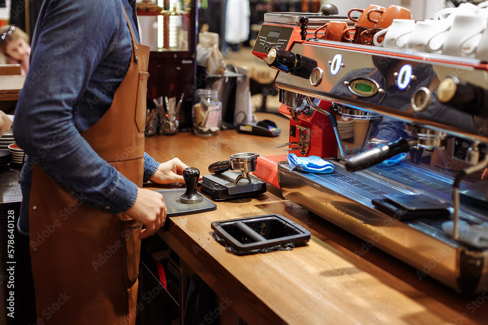 A man and a girl make coffee at a coffee machine in a coffee shop