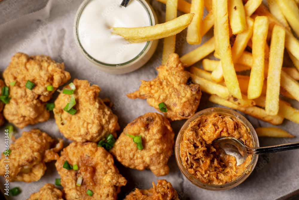 Cauliflower wings food. Cauliflower pieces and french fries with vegan sauces. Vegetarian food. Cauliflower wings food. Cauliflower pieces and french fries with vegan sauces. Vegetarian food.