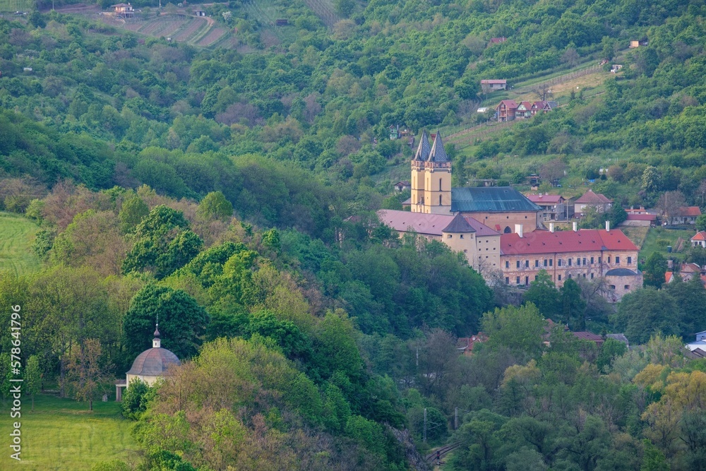 Medieval monastery in Hronsky Benadik (Slovakia), ancient Gothic building, spring nature, orchard. Gothic church in the mountains. 