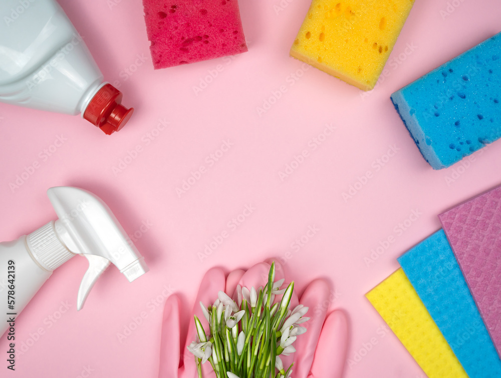 Detergent and cleaning products, kitchen sponges, rubber gloves lie in the shape of a frame on a pink background. Spring cleaning. Top view. Flatlay. Copy space. Detergent and cleaning products, kitchen sponges, rubber gloves lie in the shape of a frame on a pink background. Spring cleaning. Top view. Flatlay. Copy space.
