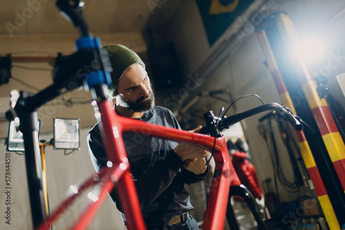 Mechanic repair man assembling custom bicycle bike in workshop