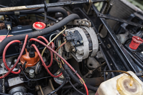 Shot of the engine compartment of a classic car with the engine  cables and alternator