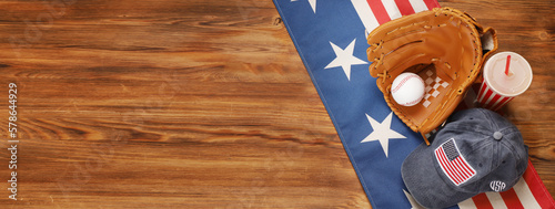 Baseball ball in a glove on the wooden table. USA flag. photo