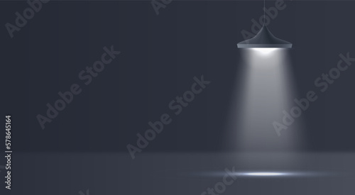Black modern 3D hanging lamp shines a bright beam of light in a dark room. Interior concept, stage lighting, horror room. Spotlight effect.
