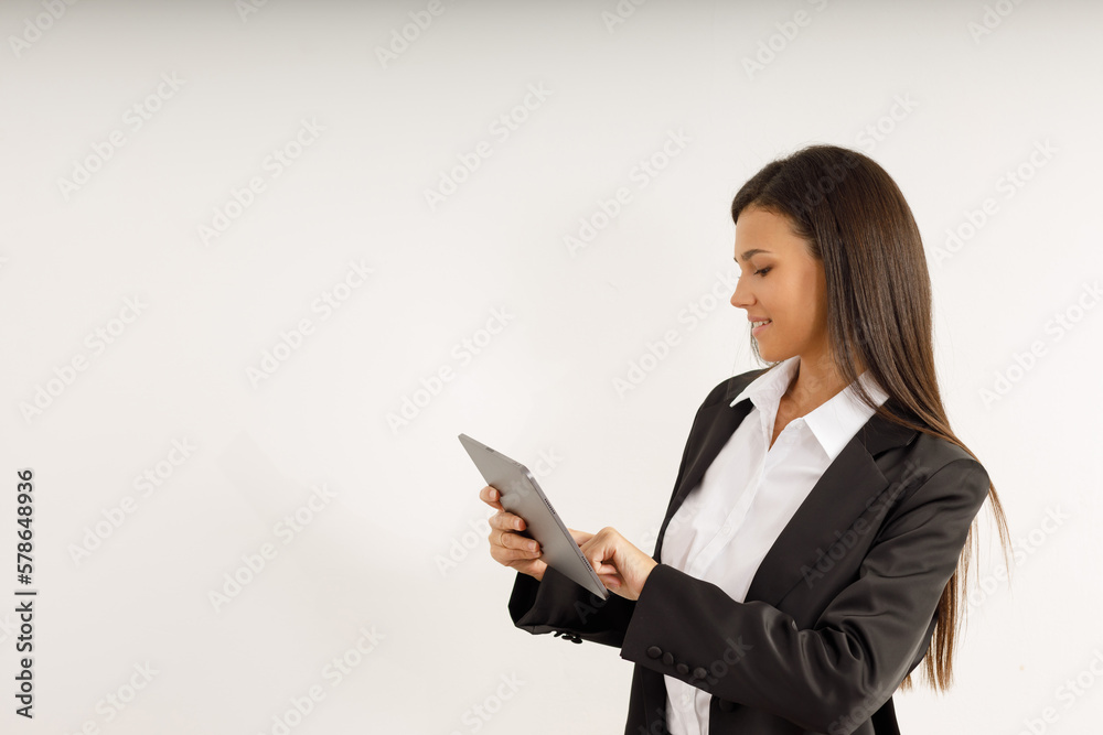 Portrait of successful business woman with tablet in her hands, dressed in white shirt and black jacket on isolated white background. Studio shot of attractive brunette girl Portrait of successful business woman with tablet in her hands, dressed in white shirt and black jacket on isolated white background. Studio shot of attractive brunette girl