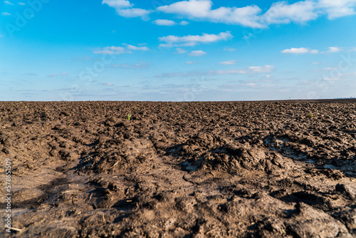 Landscape agricultural plowed in after winter field on sunny day. Field soil close up.