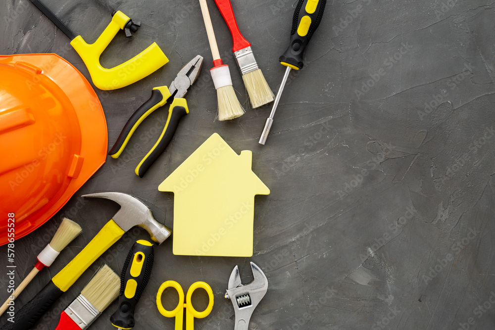 Wooden house shape with DIY hand tools and construction tooling Wooden house shape with DIY hand tools and construction tooling