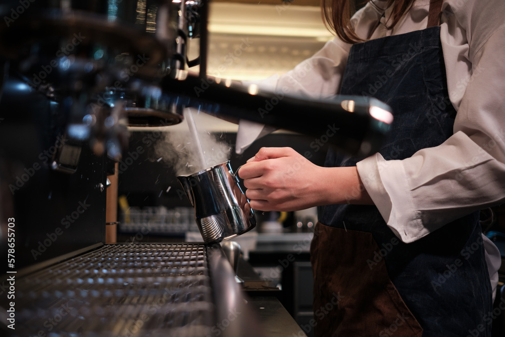 Close up of a barista preparing milk for coffee on a espresso machine in coffee shop. - obrazy, fototapety, plakaty 