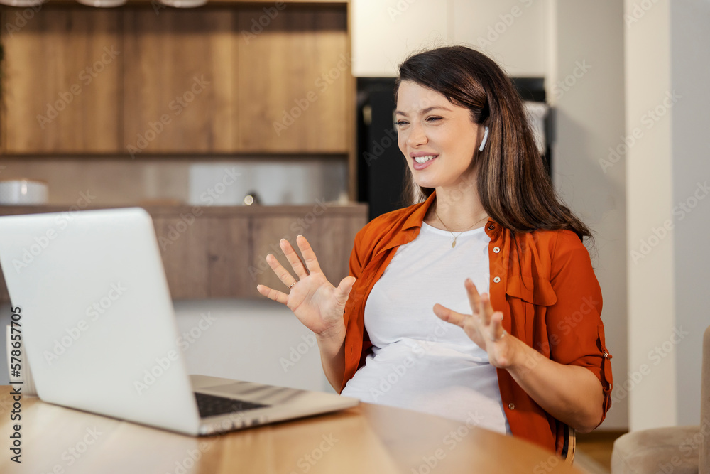 A happy pregnant woman is having video call at home with friends and family. A happy pregnant woman is having video call at home with friends and family.