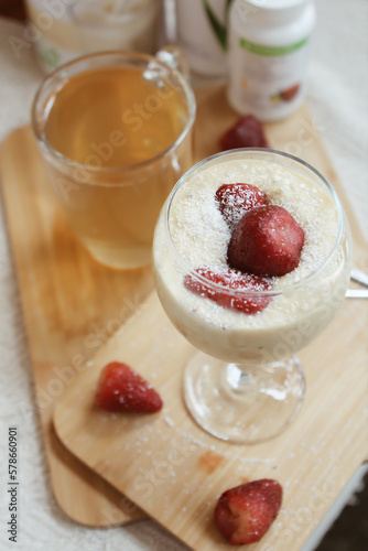 Fresh and delicious vanilla smoothie with strawberry garnish. Ideal healthy breakfast	