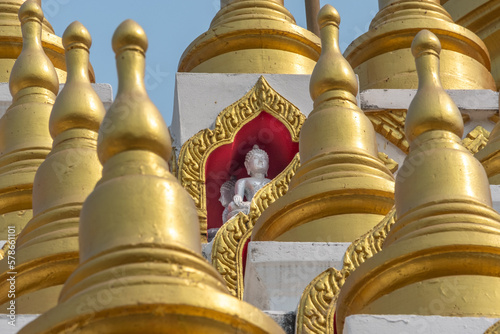 Quadro su tela Buddha statue and golden stupas at the Wat Manee Praison temple in Mae Sot Thail