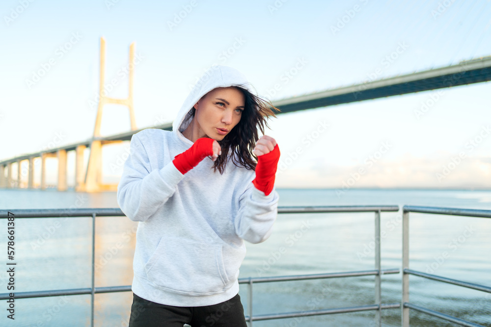Woman boxing outdoors blue sky background. - obrazy, fototapety, plakaty 