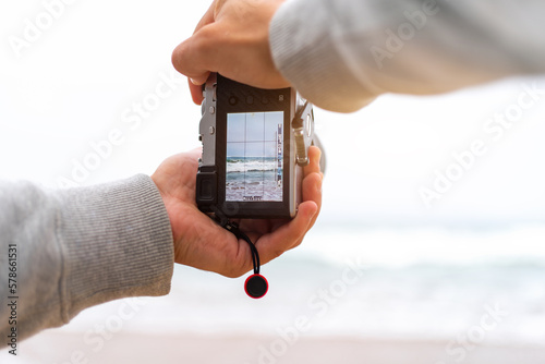 Traveller make photo holding mirrorless camera in hand