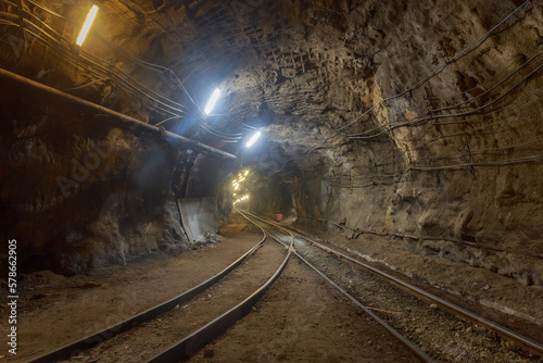 Dark tunnel of kimberlite mine with railroad.