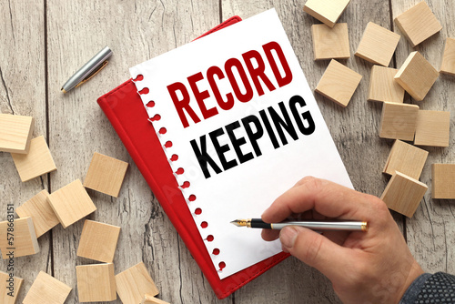 record keeping man's hand writes tex. notepad next to the cubes. business concept. education concept.