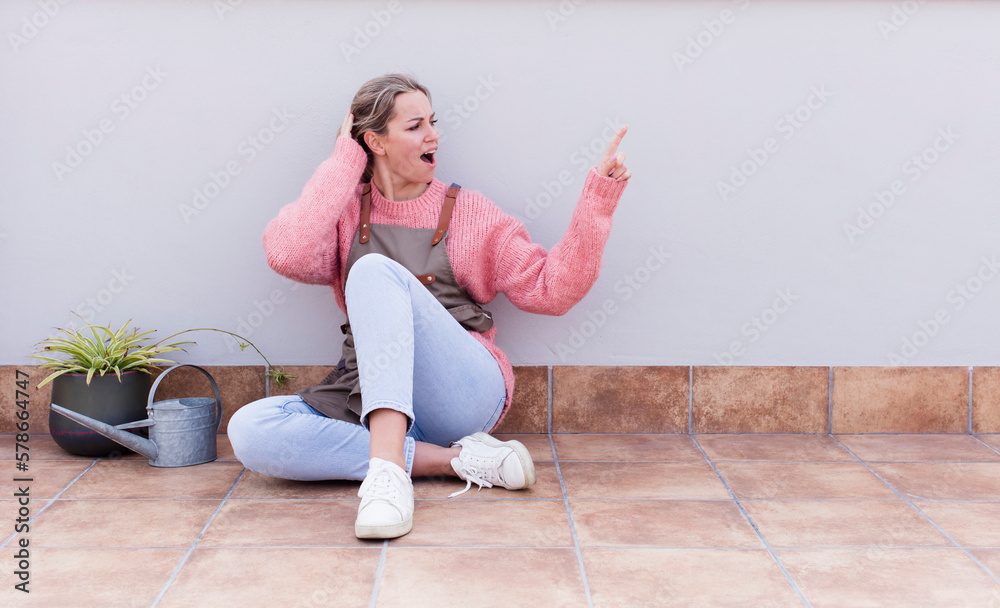 laughing, looking happy, positive and surprised, realizing a great idea pointing to lateral copy space. gardering concept laughing, looking happy, positive and surprised, realizing a great idea pointing to lateral copy space. gardering concept