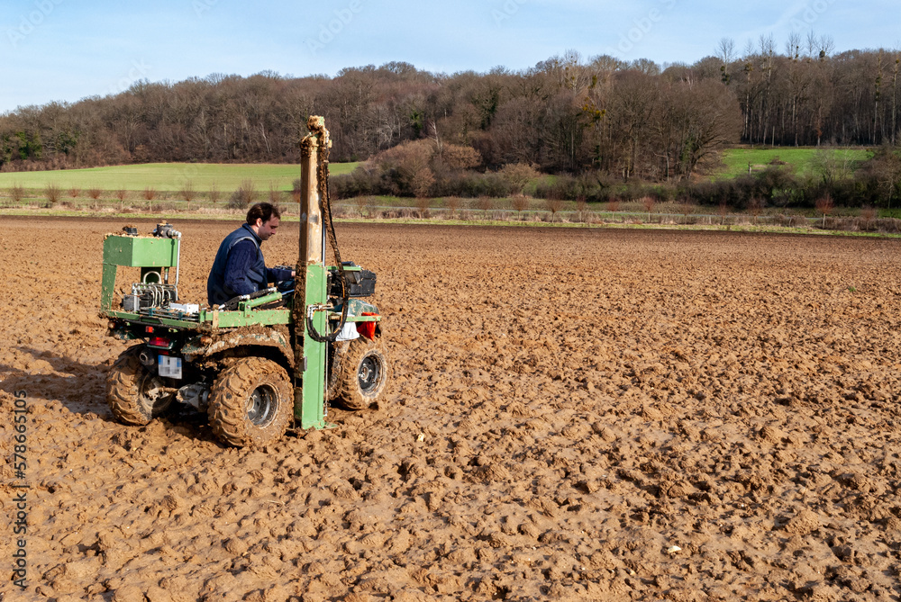 Mesure annuelle de reliquats azote dans une parcelle. Prélèvement effectué à l'aide d'un Quad équipé d'une tarrière hydraulique. Préleveur effectuant un prélévement