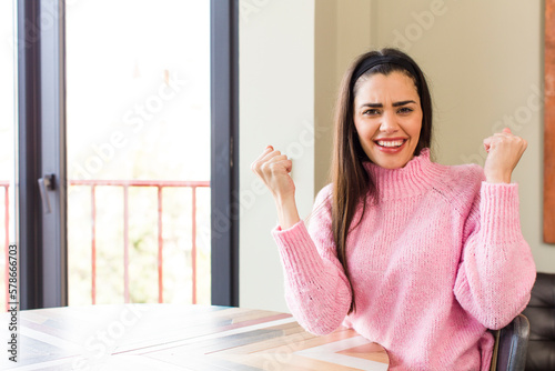 pretty caucasian woman shouting aggressively with an angry expression or with fists clenched celebrating success