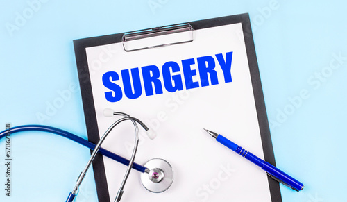 Wallpaper Mural On a blue background, a stethoscope, a pen and a tablet with paper and the text SURGERY. Medical concept Torontodigital.ca
