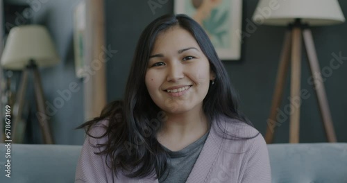 Wallpaper Mural Slow motion portrait of cheerful Asian woman smiling and looking at camera in cozy apartment. Modern lifestyle and millennials concept. Torontodigital.ca