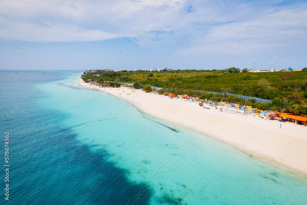 The picturesque Nungwi beach in Zanzibar, Tanzania is showcased in a toned aerial view image, highlighting the luxury resort and turquoise ocean waters. The picturesque Nungwi beach in Zanzibar, Tanzania is showcased in a toned aerial view image, highlighting the luxury resort and turquoise ocean waters.