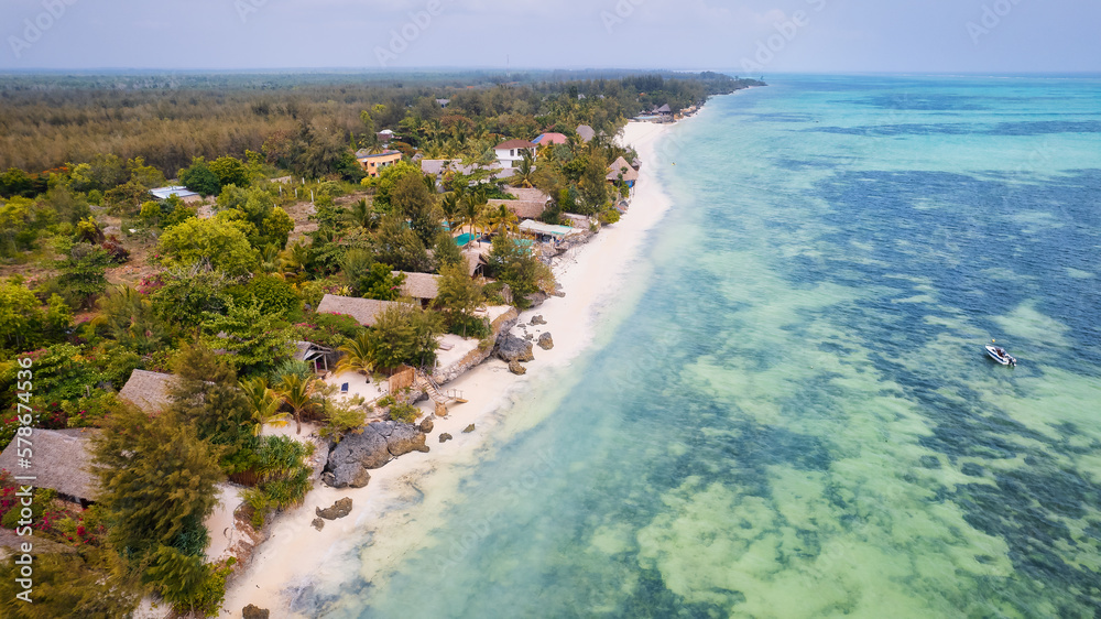 The turquoise ocean water and the luxurious resort on Kiwengwa beach in Zanzibar, Tanzania, are captured in this gorgeous toned aerial view. The scenery is simply stunning, and it's a perfect destinat The turquoise ocean water and the luxurious resort on Kiwengwa beach in Zanzibar, Tanzania, are captured in this gorgeous toned aerial view. The scenery is simply stunning, and it's a perfect destinat