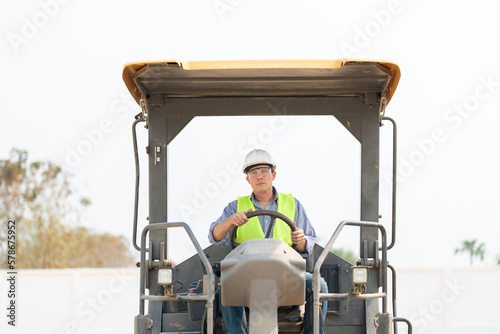 Construction engineers and foreman worker working at construction site, worker driving tractor for survey the project.