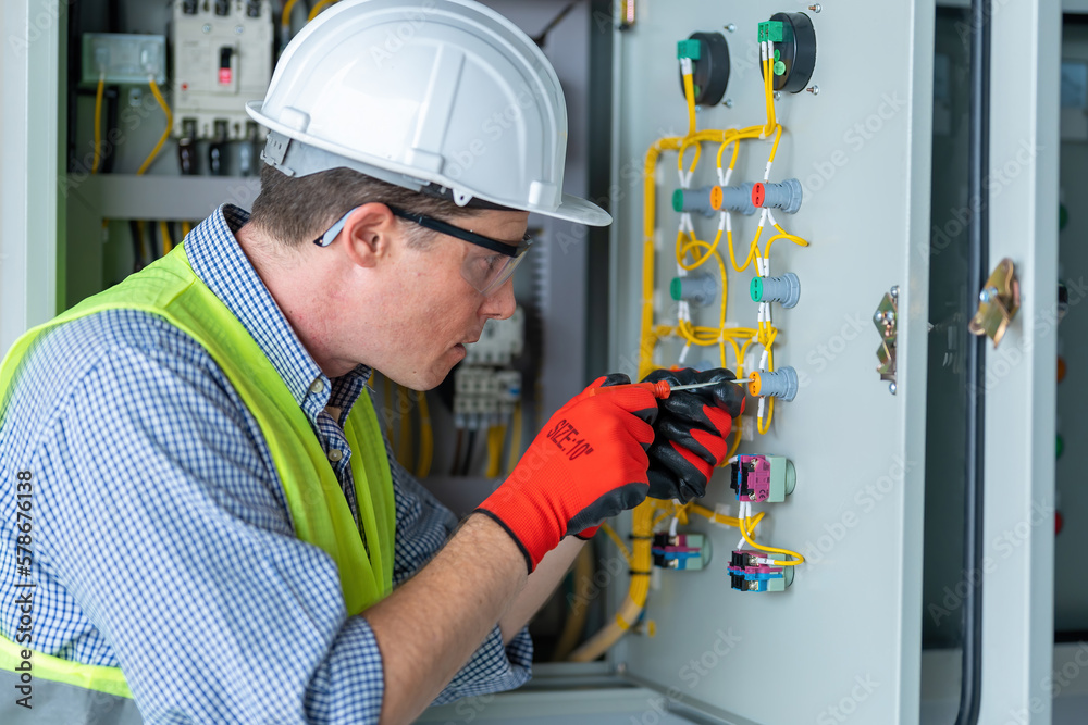 Electrician installing electrical wires and multimeter fuse switch box in hands of electrician detail