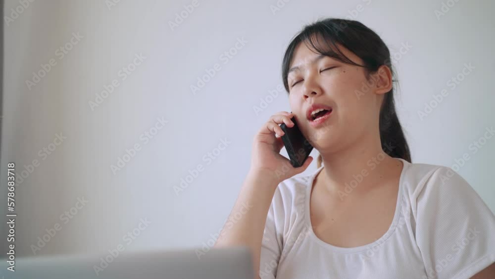 Asian woman talking on the phone in the living room at home. Asian woman talking on the phone in the living room at home.