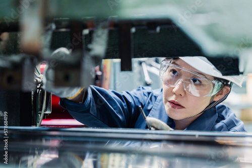 Foto 機械の保守点検をする女性技術者