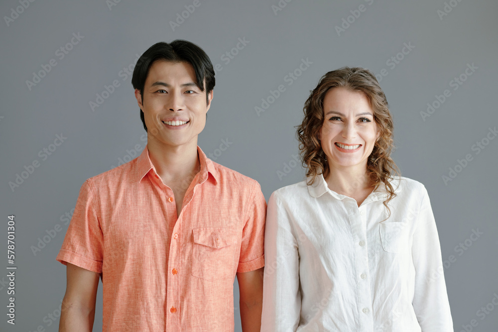 Happy couple with age difference posing against grey background Happy couple with age difference posing against grey background