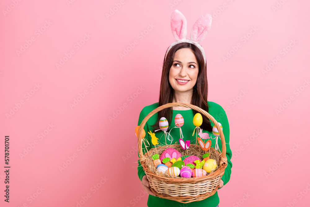 Photo of pretty cheerful person hands hold festive easter basket painted eggs cookies food look empty space isolated on pink color background