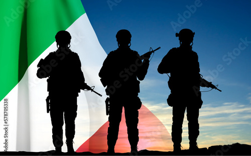 Silhouettes of a soldiers with Italian flag against the sunset. Armed Forces of Italy. EPS10 vector