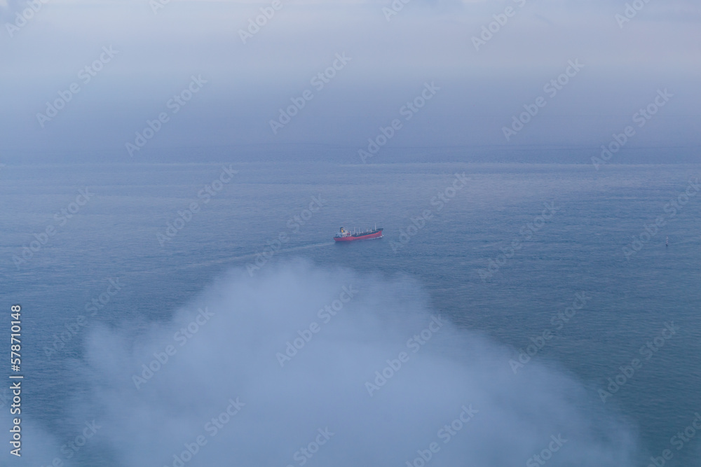 Fototapeta premium Boat on the ocean water and clouds