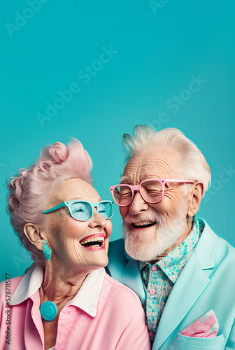 Cheerful senior Caucasian couple in colorful extravagant outfits and glasses with gray hair smiling against turquoise background. Generative AI.
