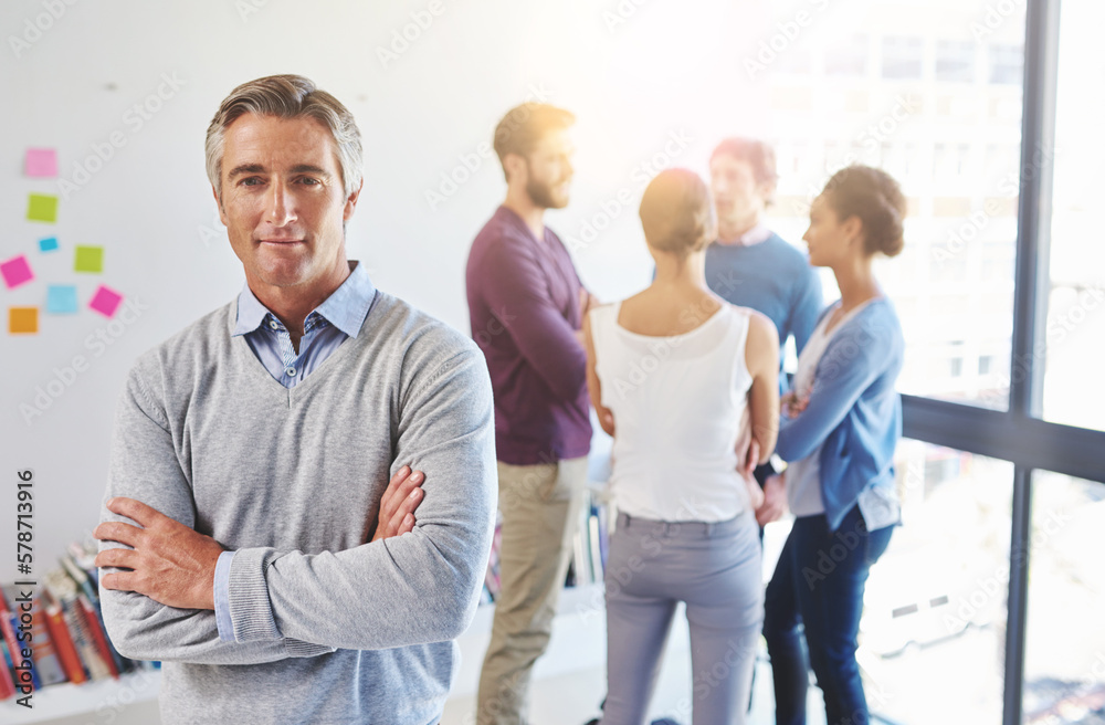 Obraz premium Hes an excellent leader. Portrait of a mature businessman with his colleagues standing in the background.