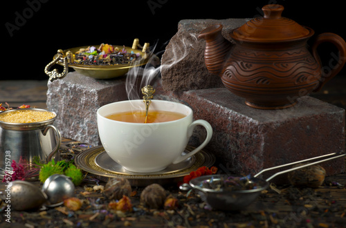 Sweet  hot tea with dry tea leaves  on an old background.