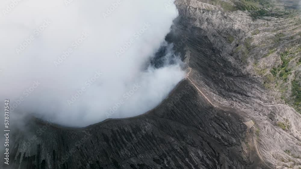 Bromo volcano caldera in Bromo-Tenger-Semeru National Park. Drone flying over a smoking crater Bromo volcano caldera in Bromo-Tenger-Semeru National Park. Drone flying over a smoking crater