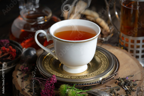 Sweet  hot tea with dry tea leaves  on an old background.