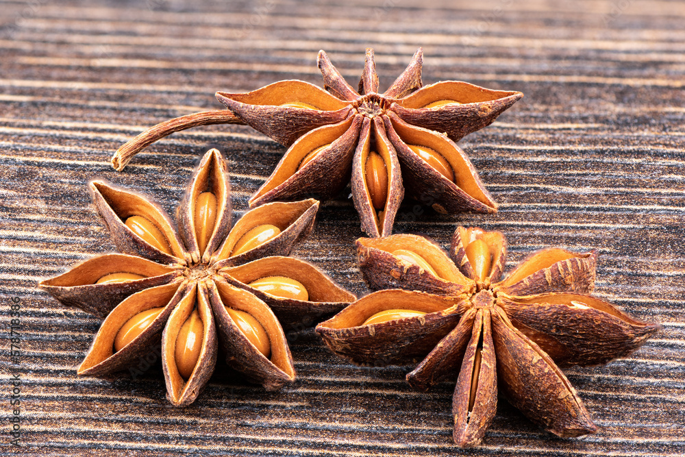 Close-up of three star anise on a wooden background.