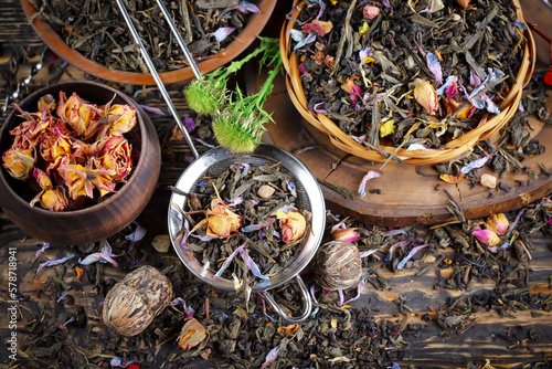 Dried tea leaves in a spoon, on an old background.