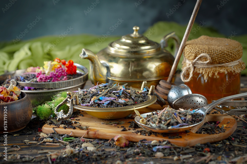 Dried tea leaves in a spoon, on an old background. Dried tea leaves in a spoon, on an old background.