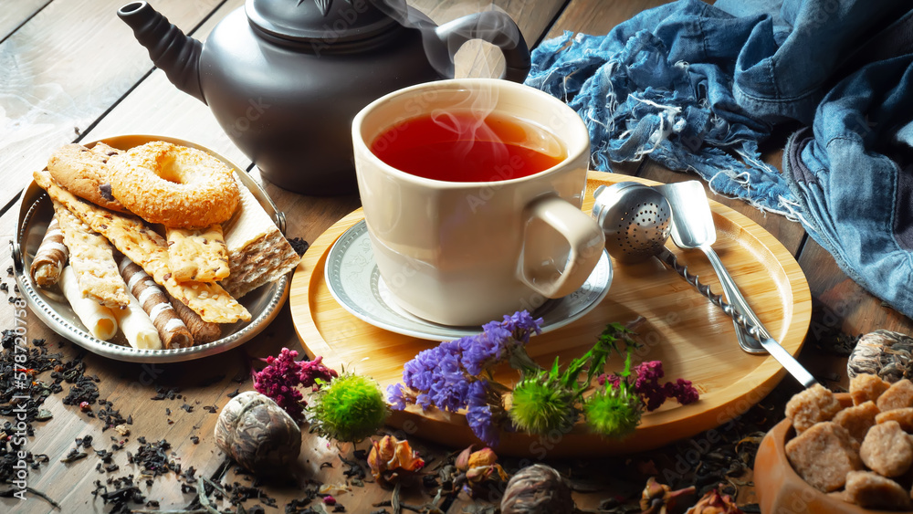 Fototapeta premium Sweet, hot tea with dry tea leaves, on an old background.
