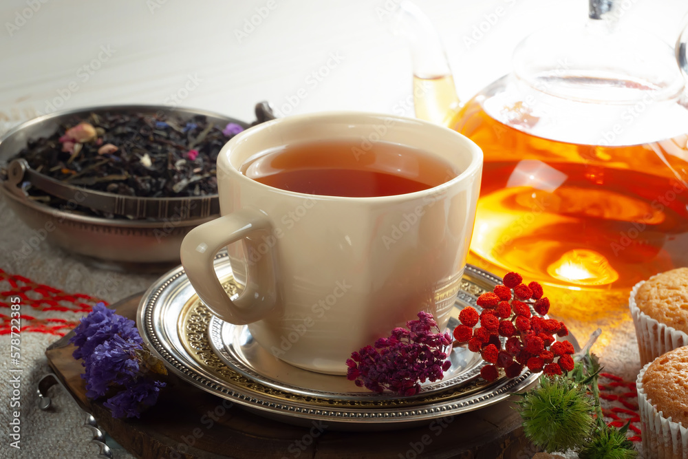Sweet, hot tea with dry tea leaves, on an old background. Sweet, hot tea with dry tea leaves, on an old background.