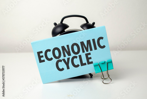economic cycle is written in a blue sticker near a black alarm clock