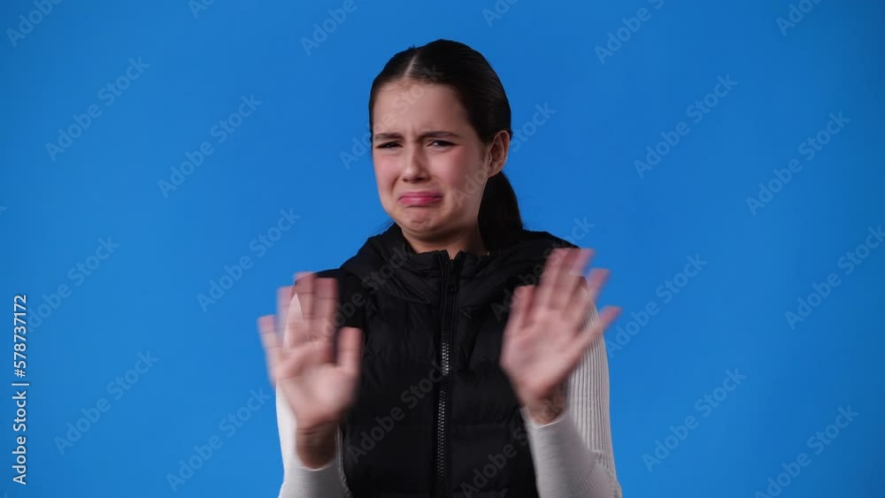 4k video of one girl which responds negatively to something over blue background. 4k video of one girl which responds negatively to something over blue background.