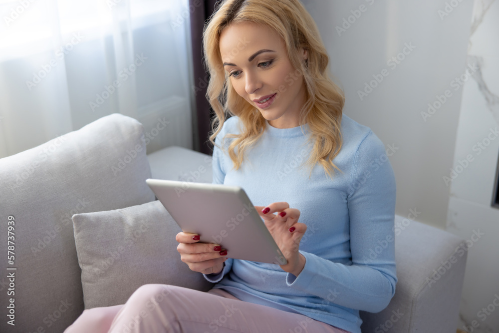 Concentrated woman using her tablet computer at home Concentrated woman using her tablet computer at home