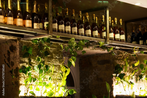 Estantería de vinos y champañas en restaurante con decoración natural photo
